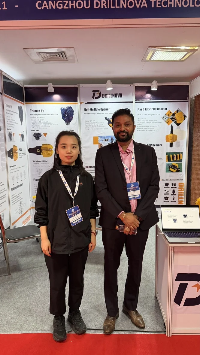 A photograph at the DRILLNOVA booth, with HDD tool displays in the background.