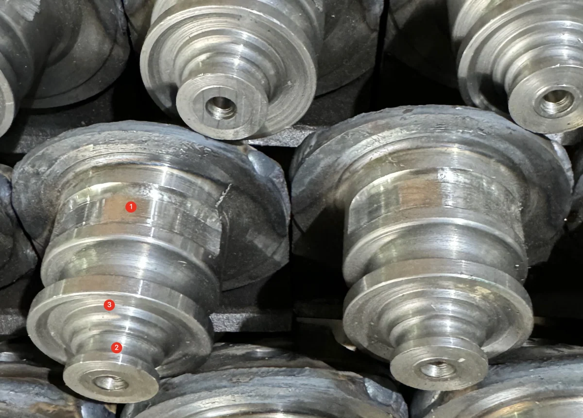 Prepared grooves on steel roller-bit journals; original numbered marks retained.