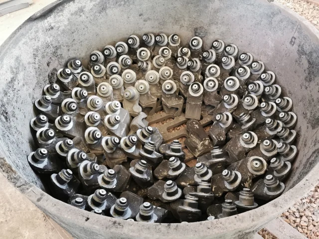 Roller-bit legs arranged in a heat-treatment vessel.