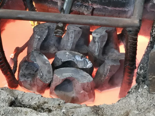 Roller-bit legs inside a heated furnace.